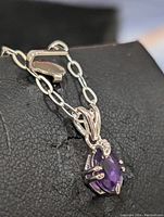 Close-up of pendant showcasing amethyst and silver detailing on a chain with box clasp.