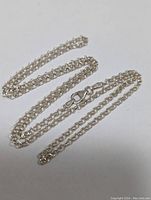 Sterling silver chain necklace laid out showing chain length and lobster clasp.