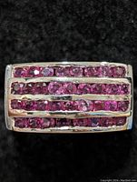 Close-up of the rectangular top of the ring showing three parallel rows of small round red rubies set in sterling silver
