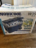 Box of Mobicool W35 12 Volt Portable Cooler with Wheels, shows branding and product image on front.