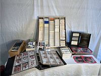 Overview of large collection of hockey cards shown spread out including boxes and binders