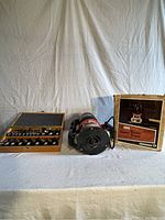 Craftsman router with bit case and original box displayed on white cloth background