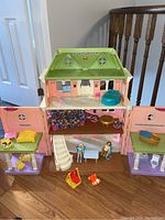 Front view of the three-section dollhouse with various furniture and two dolls inside