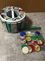 Rotating plastic holder containing multiple stacks of collectible aircraft coins with vintage airplane designs and denominations, plus loose coins in a plastic bag