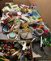Wide view of large mixed lot of Playmobil pieces mostly buildings and accessories scattered on a table.