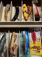 Top view of tackle box compartments filled with various vintage fishing lures
