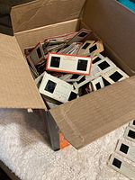 Open box filled with numerous stereo slides in cardboard mounts, some handwritten labels visible.