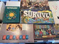 All four vintage board games displayed together: Astrology, Masterpiece, Survive!, Stratego.