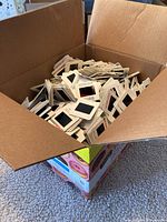 Open cardboard box filled with hundreds of photographic slides in paper mounts, assorted orientations and stacked loosely inside