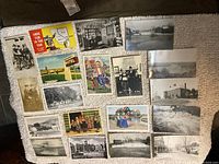 Top view of 19 assorted vintage postcards laid out showing their fronts with various historic buildings, people in traditional costumes, scenic views, and advertisements.