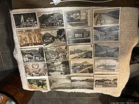 Photo of 20 assorted vintage postcards laid out on a surface, showing various scenes including landscapes, architecture, and animals.