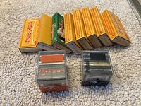 View of 8 yellow and green boxes labeled for Hong Kong slides and two slide holders on beige carpet