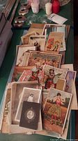 Top view of assorted vintage trade cards and postcards with colorful imagery and text