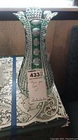 Full view of the green cut crystal glass vase showing its height and pattern.