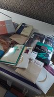 Photo of various vintage stocking and girdle packages arranged on a table, showing multiple brands and packaging designs.