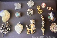 Lot of various costume jewelry pins including cameo designs, enamel pins, floral and abstract motifs.