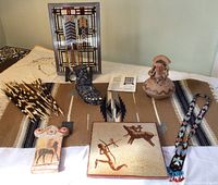 Wide view of lot showing stained glass panel, ceramic items, painted tile, woven textile and beaded necklace.