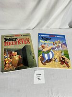 Two Asterix comic books side by side, French and English editions visible.
