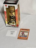 Unopened Eric Lindros bobblehead in a Montreal 1998 Olympics box and signed rookie card in display case.