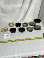 Overview of 10 casino ashtrays displayed in a row showing size and condition