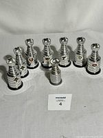 Eight mini trophies including seven Labatt's Beer Stanley Cup replicas with NHL team logos and one Coleco mini trophy.