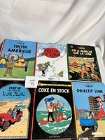 Photo showing all six books arranged with colorful illustrated covers, identifying them as vintage French Tintin comic books.