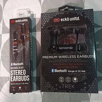 Two boxed sets of Ecko Unltd wireless stereo earbuds side by side, showing front packaging with branding and features