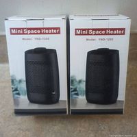 Two boxed mini space heaters model YND-1200 in factory packaging.