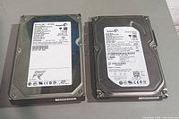 Top view of two Seagate hard drives side by side showing their product labels and specifications.