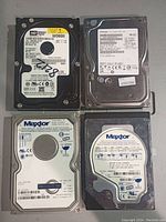 Four 3.5 inch internal hard drives, two Western Digital and two Maxtor, showing labels with model, capacity, serial numbers.