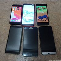 Six smartphones laid out in two rows on counter