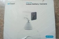Front view of ioGeek wire-free indoor battery camera in original packaging showing model 2S-GX7S.