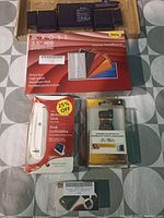 Top view showing black rechargeable batteries and various retail boxed electronic accessories including IKROSS HDD enclosure, Sony PSP memory stick, and Sony Ericsson dock.