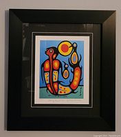 Full view of framed artwork showing vibrant colors and black frame.