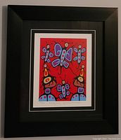 Full view of the black framed colorful print "Butterfly Family" with butterflies on a red background, with matting.