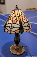 Photo of the lamp showing full view with stained glass dragonfly shade and metal base.