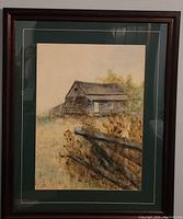 Full view of framed watercolour painting showing the farmhouse, fence, and foliage in earthy tones with green matting and dark wooden frame.
