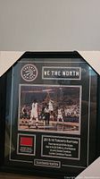 Framed display showing Raptors logo, "WE THE NORTH" slogan, authentic floor piece, and commemorative photo from the 2015-16 NBA season