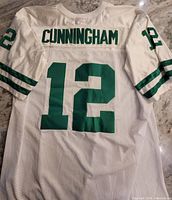 Back view of white jersey showing green "CUNNINGHAM" name and number 12, with sleeve stripes and number 12.