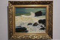 Frontal image of the oil painting within a decorative gold frame, showing the full seascape scene with waves and rocks.
