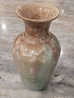 Side angle view of vase showing beige and green crystalline glaze patterns with flared rim.