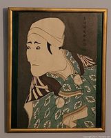 Framed Ukiyo-e print showing full view of Kabuki actor in patterned kimono with inscription.