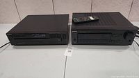 Two black audio components side by side: Sony CD player on the left and Sony receiver on the right with remote on top of receiver.