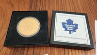 Bronze collector coin in black presentation box with removable lid. Lid shows Toronto Maple Leafs logo and Limited Edition Commemorative text.