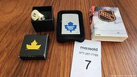 Full view of the lot showing the Zippo lighter in black insert, men's sports ring in black box, and NHL collector packaging.