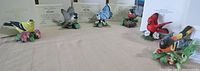 Six figurines: American Goldfinch, Chickadee, Blue Jay, Robin, Cardinal, Oriole in front of certificates