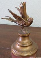 Brass bird figurine with wings spread on round stepped base