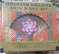 Front of the origami deluxe box showing included items and decorative designs on paper