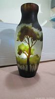 Front view of cameo-style layered glass vase showing tree silhouette design and dark brown rim