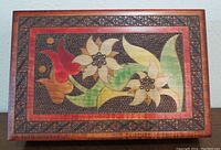Decorative wooden box lid with colorful floral inlay and detailed border pattern